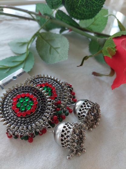 Sølvfarget ørepynt med dataljer i rødt