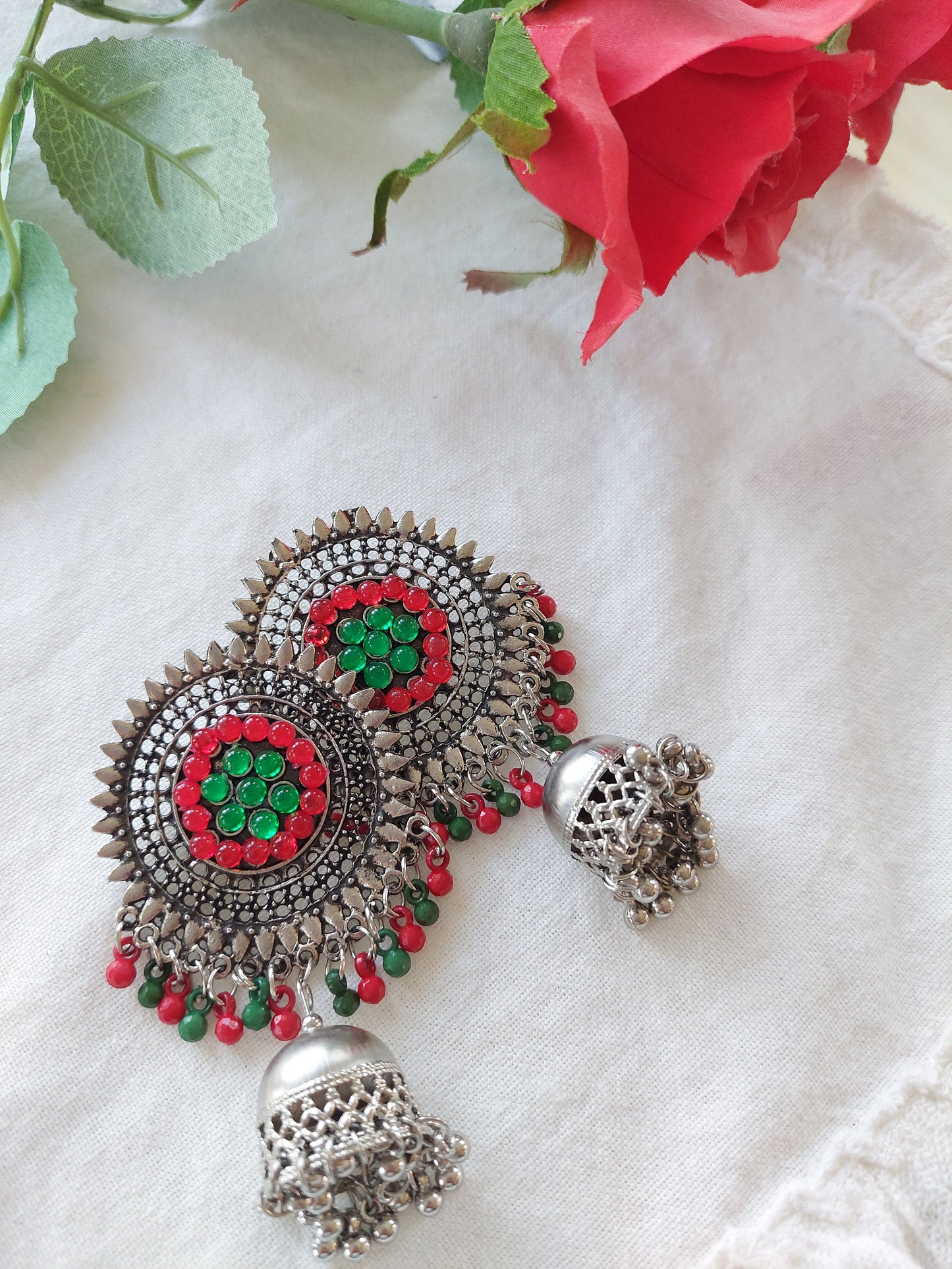 Sølvfarget ørepynt med dataljer i rødt