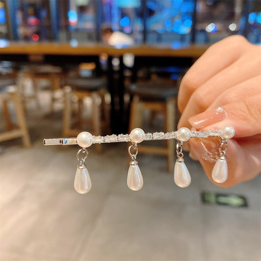 Hårspenne i gull og sølvfarge med hengende perler