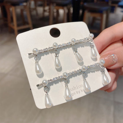 Hårspenne i gull og sølvfarge med hengende perler
