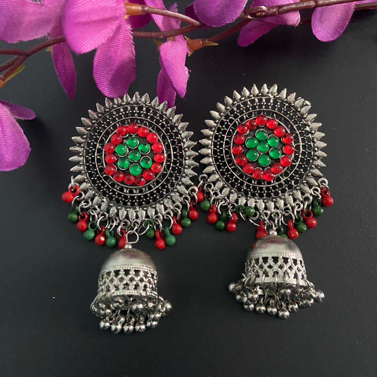 Sølvfarget ørepynt med dataljer i rødt